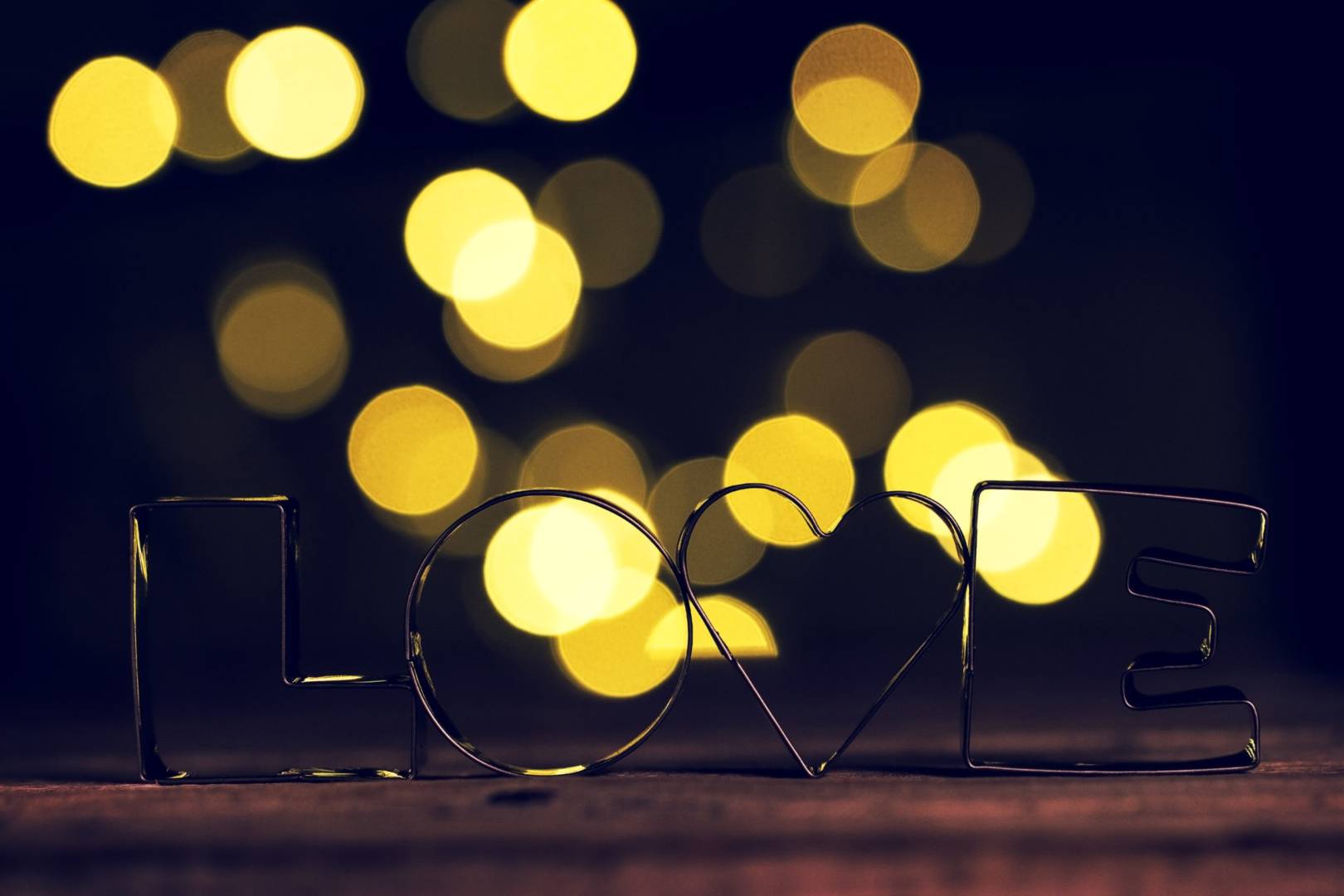 Love or Valentine's Day Concept with Metal Letters LOVE on a wooden background with bokeh.